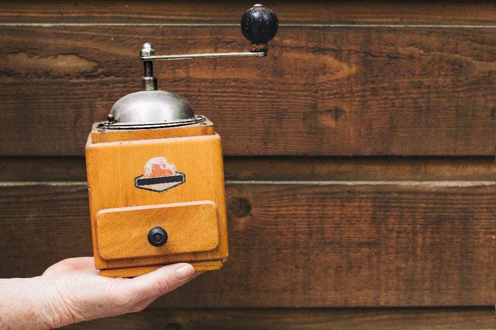 antique coffee grinder held in hand